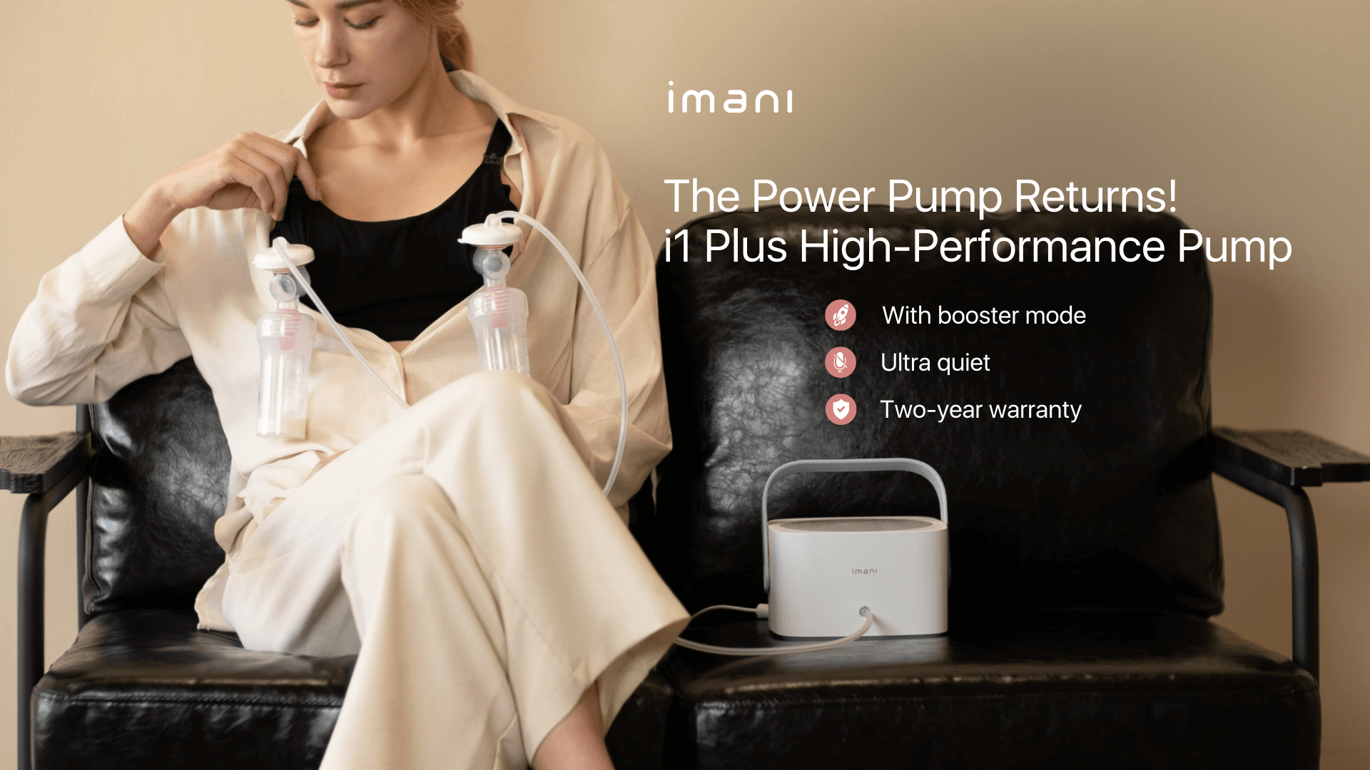 Woman using imani i1 Plus double electric breast pump while seated on a sofa
